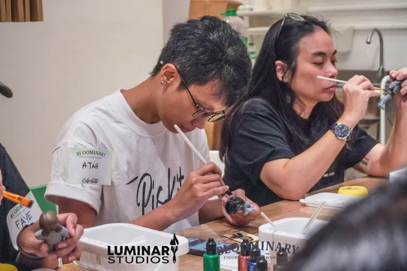 Painters focused on brushwork at the table