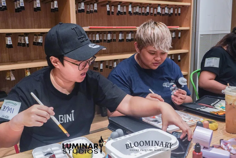 Two painters working side by side with brushes
