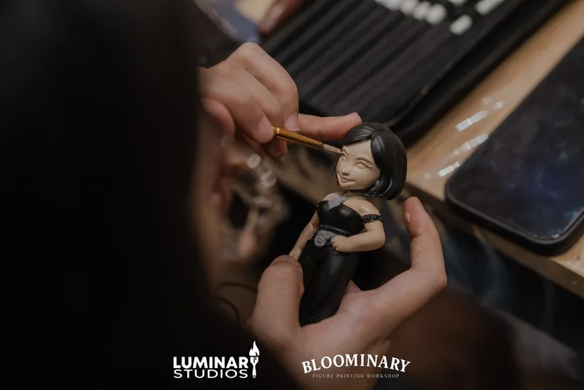 Brush painting the face of a figure