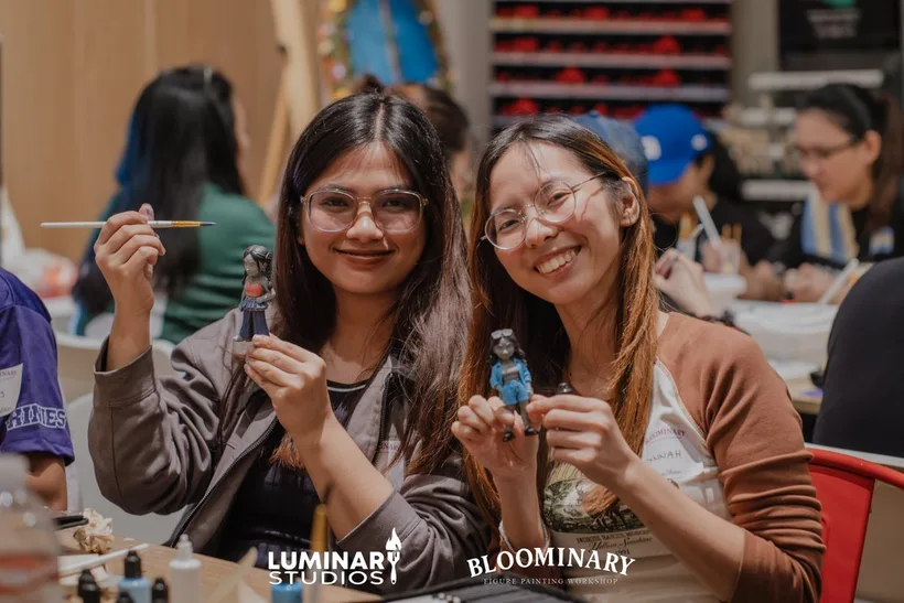Two painters smiling with their figures