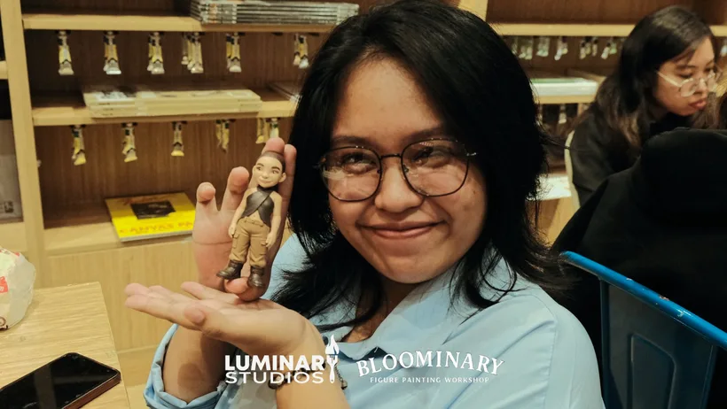 Painter smiling while holding a finished figure