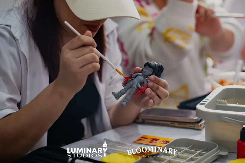 Painter brushing color onto a seated figure