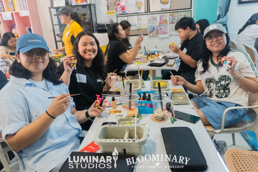 Painters smiling with figures at the table