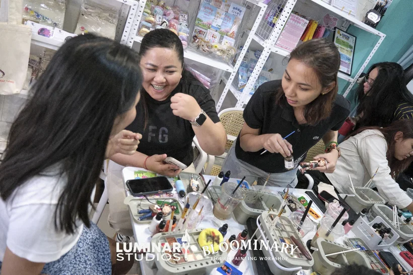 Friends laughing together at the paint table