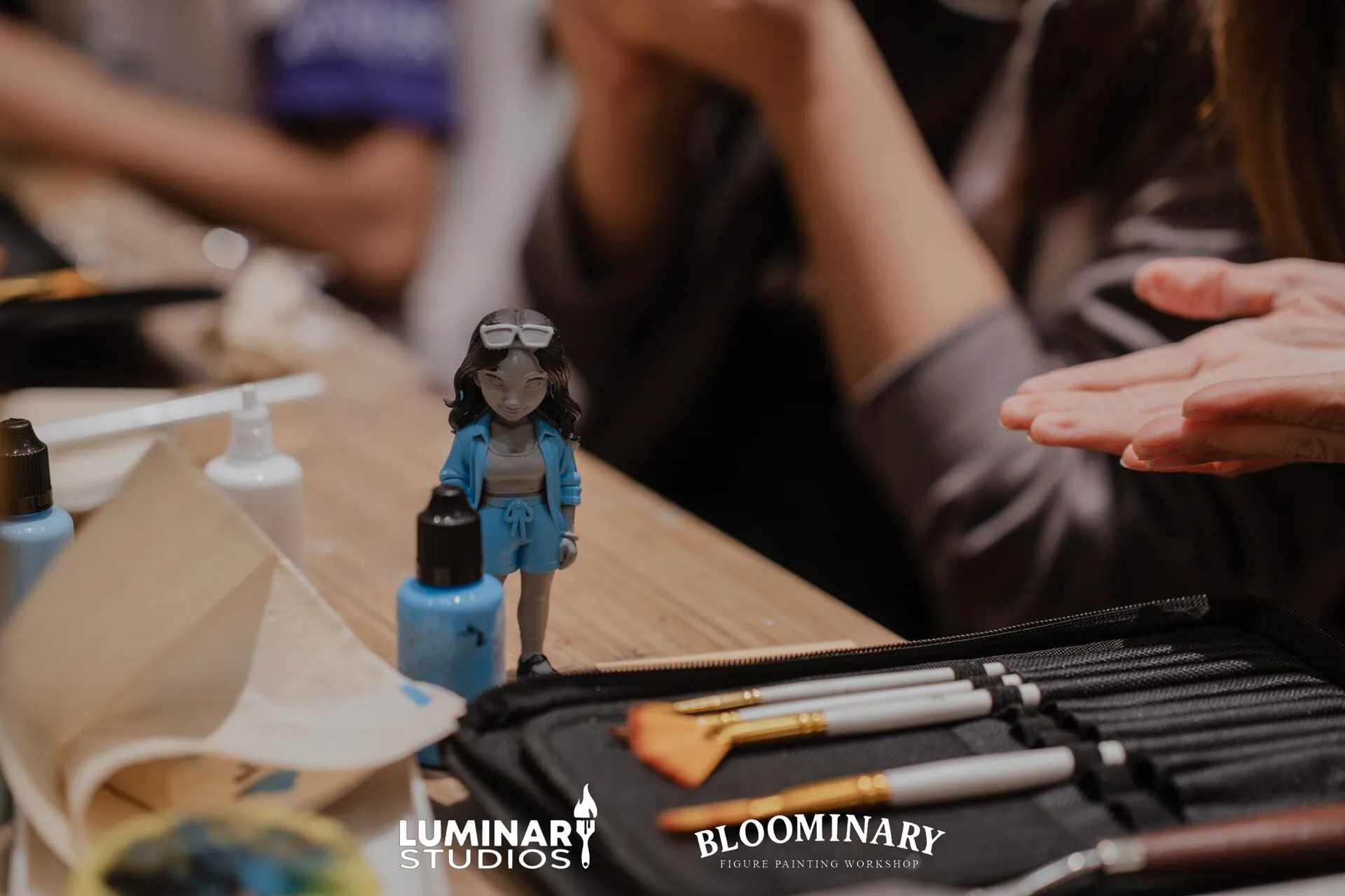 Workshop figure on table with brushes